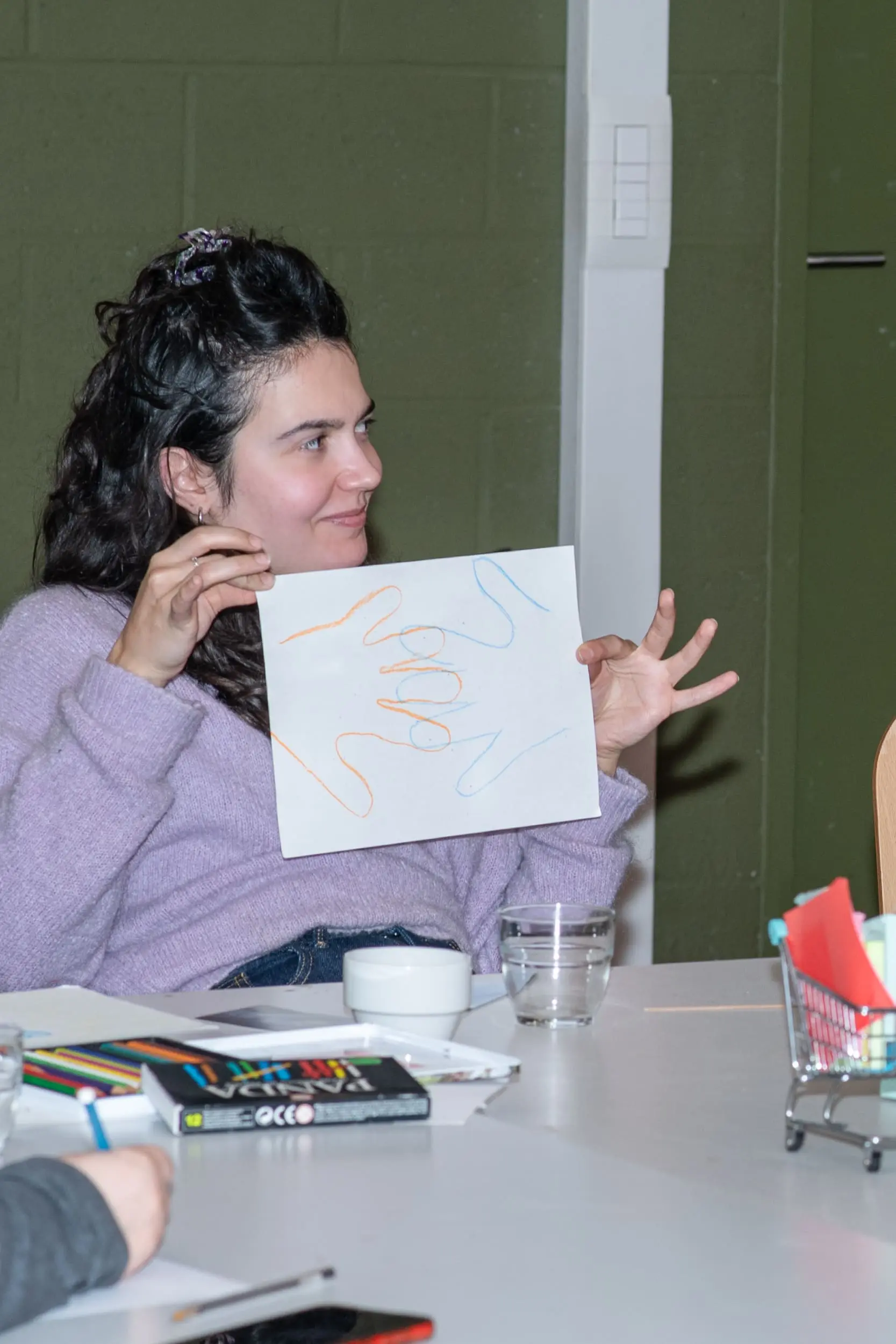 Une photo d’une participante montrant la représentation créative, coconstruite avec sa partenaire pendant l’activité brise-glace et connexion, lors d’un atelier dintelligence collective à la Maison des Femmes de Schaerbeek. oplic asbl